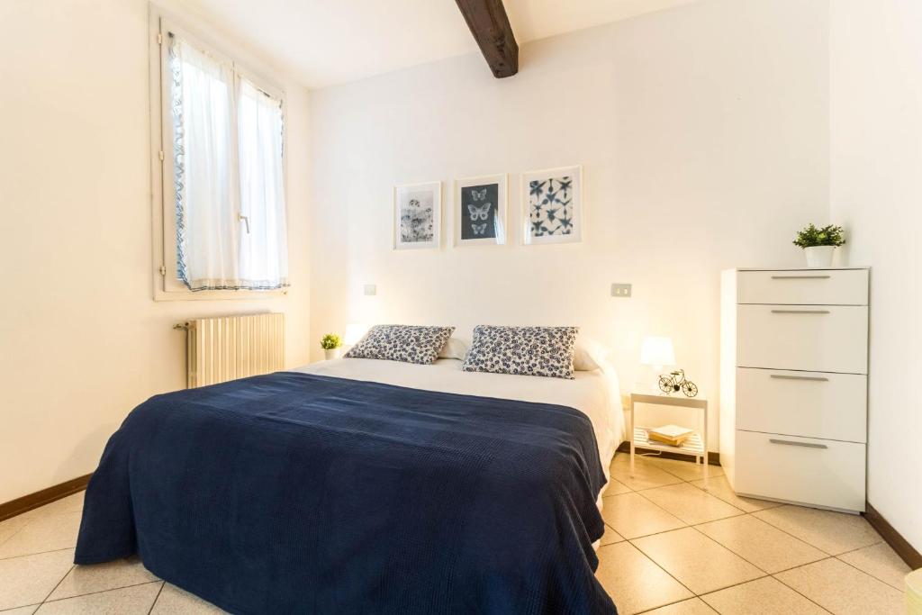 1 dormitorio blanco con 1 cama y vestidor en Al Pipái, en Ferrara