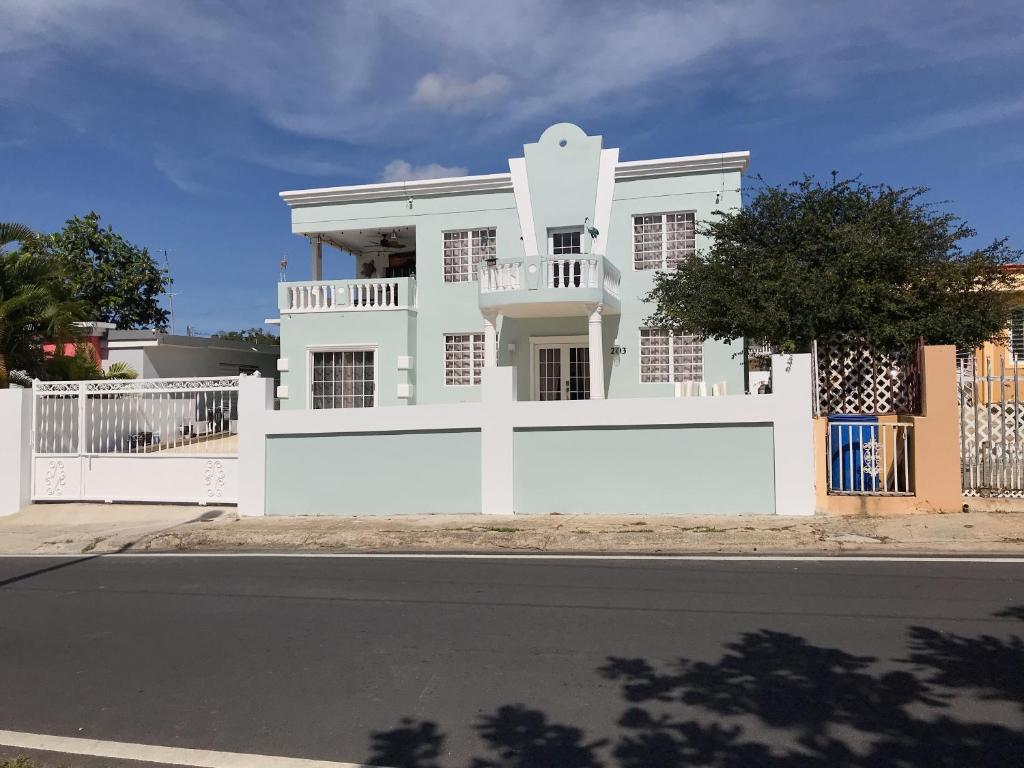 a white house with a white fence in front of a street at Luxury Villa Salgado in Tierras Nuevas Poniente