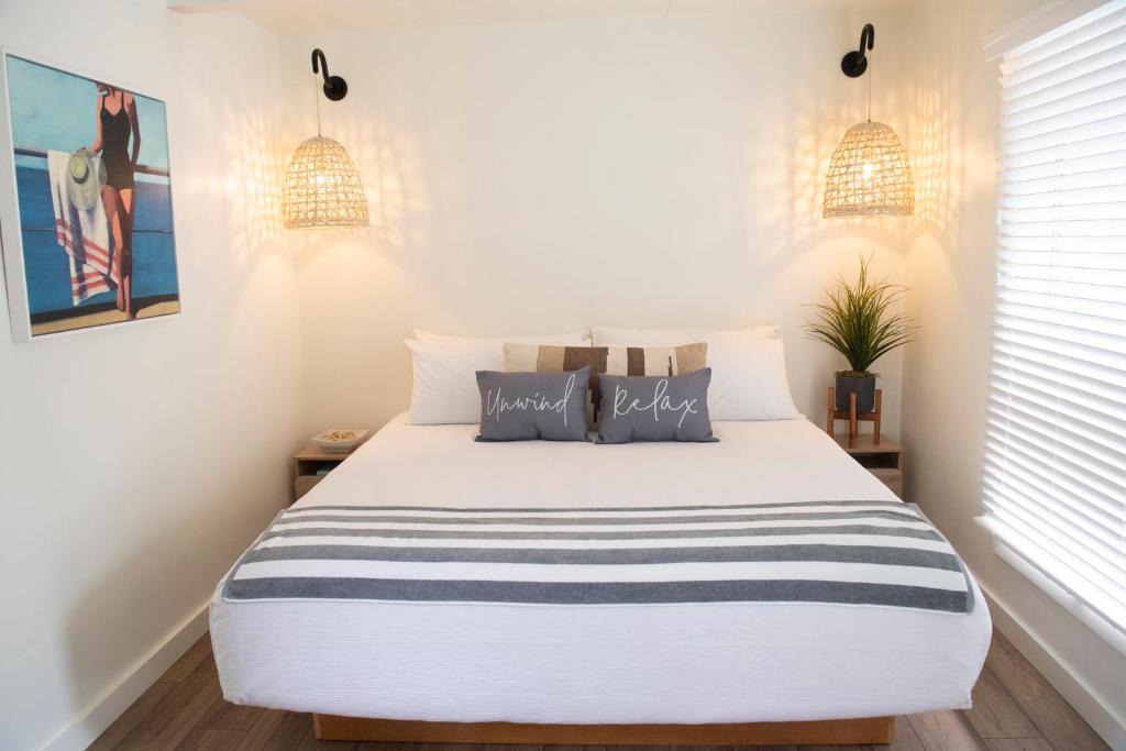 1 dormitorio con 1 cama blanca grande y 2 luces en Endless Coast, A Boutique Hotel, en Wellfleet