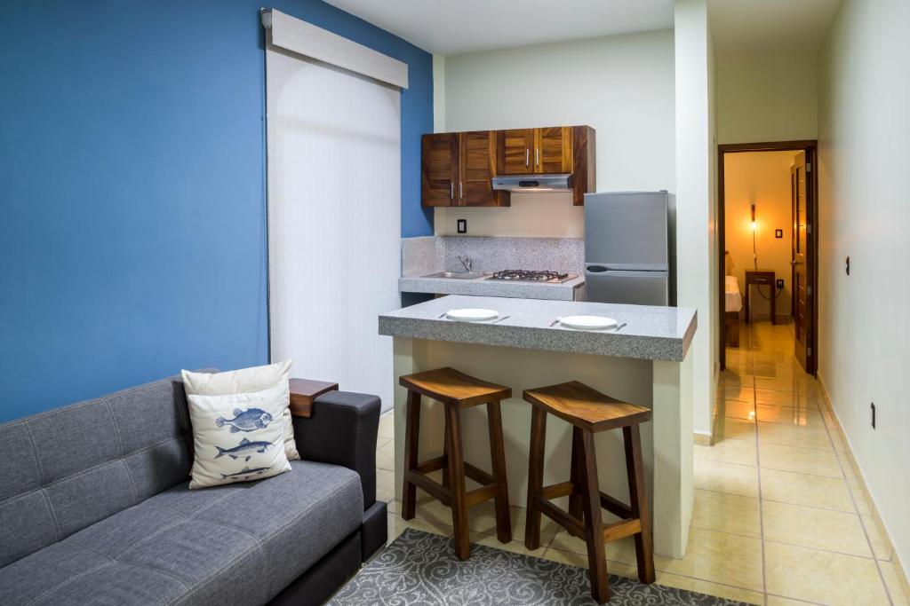 a living room with a couch and a kitchen at Punto Mita Eco Surf Suites in Punta Mita