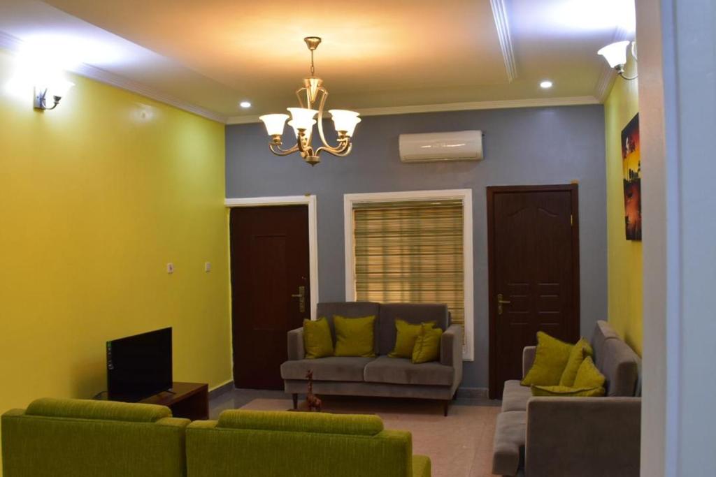 a living room with two couches and a tv at Kay's ville Apartment in Abuja