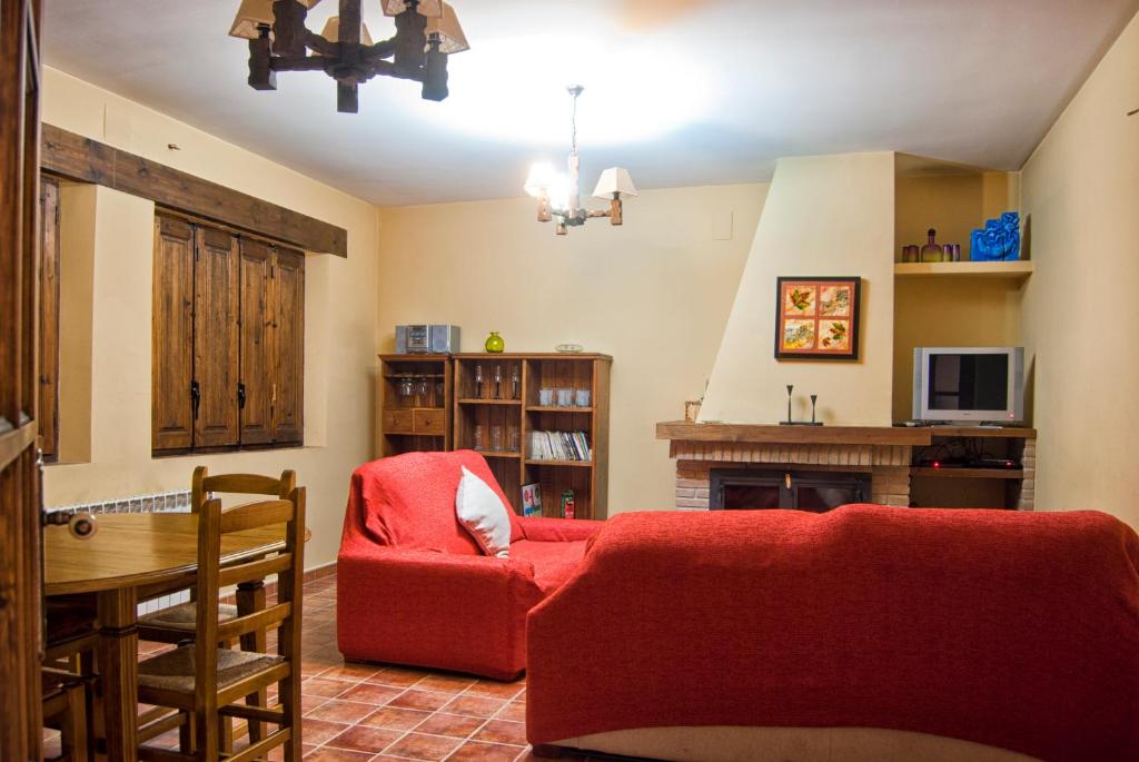 a living room with a red couch and a table at Casa Rural Campoamor in Riópar
