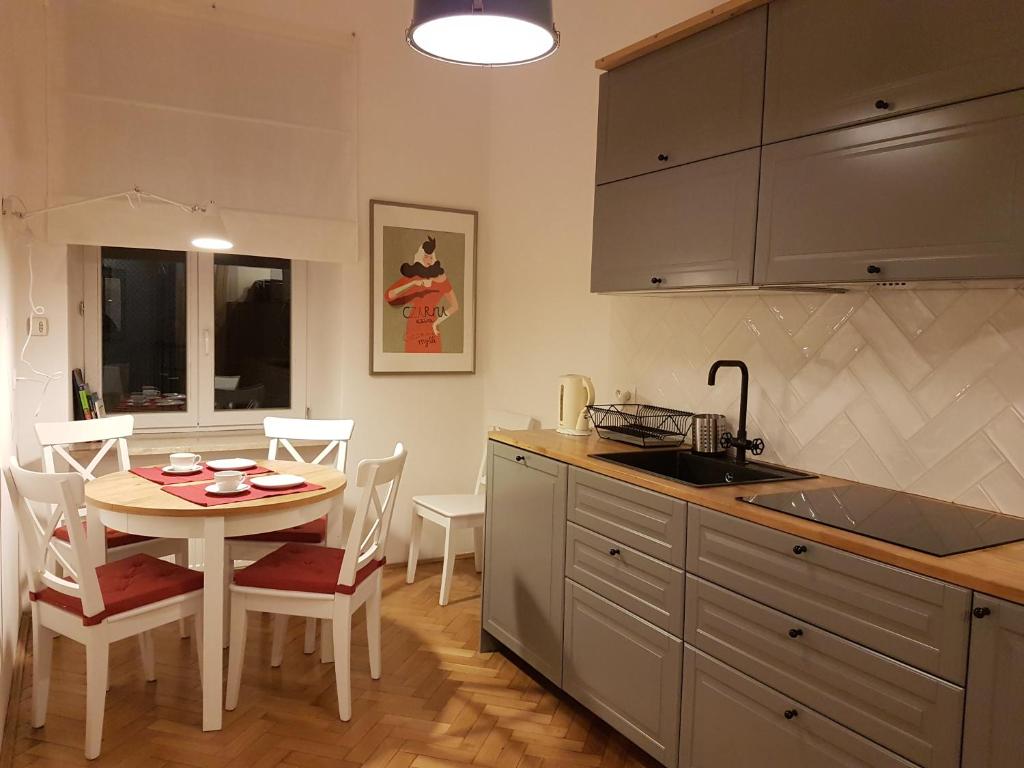 a kitchen and dining room with a table and chairs at Zakamarki in Kraków