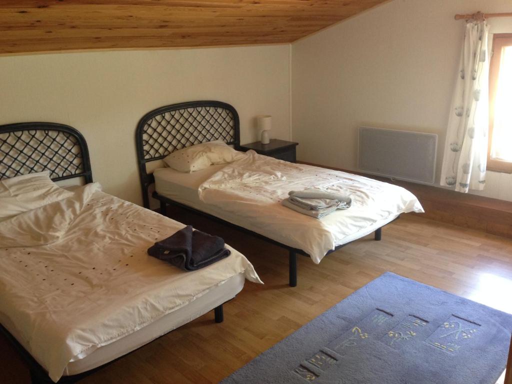 a bedroom with two beds and a blue rug at Les Reves B&amp;B Chambres d&#39;Hotes et Table d&#39;Hotes in Arques