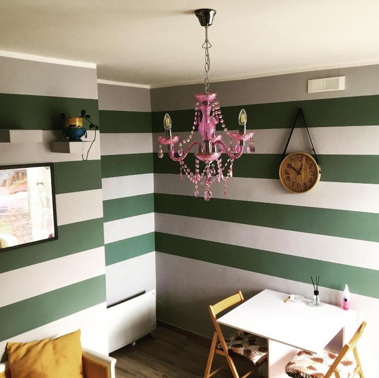 ein Esszimmer mit gestreiften Wänden und einem rosa Kronleuchter in der Unterkunft Suite 01 in Montesarchio