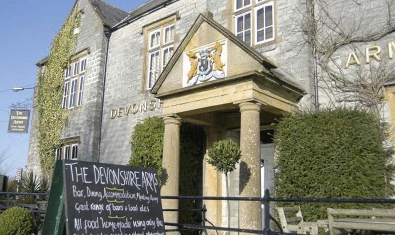 een gebouw met een bord ervoor bij Devonshire Arms in Langport