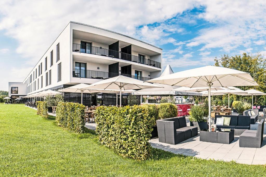 een gebouw met parasols, stoelen en tafels bij Schlosshotel Hellenstein in Heidenheim an der Brenz