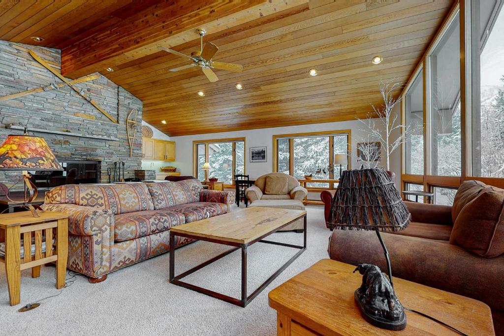 a living room with couches and a wooden ceiling at The Clymer House in Teton Village
