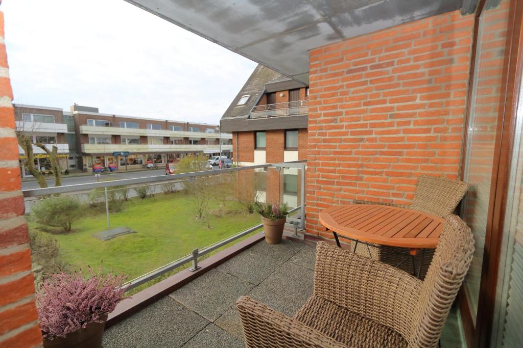 a patio with a table and chairs on a balcony at Entennest am Dorfteich in Wenningstedt