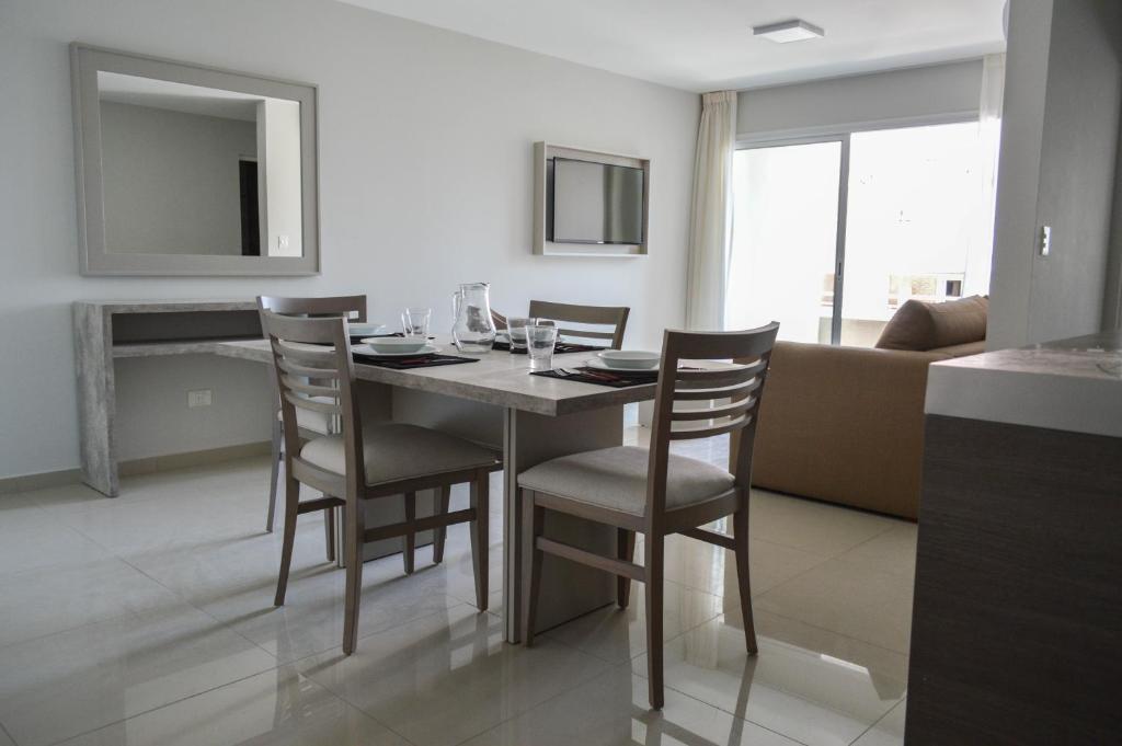 a dining room with a table and chairs and a couch at Live Inn Neuquen in Neuquén