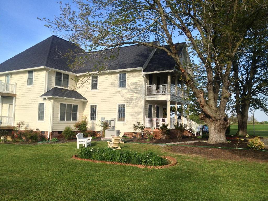 Casa blanca grande con porche y árbol en Ma Margarets House Bed and Breakfast, en Heathsville