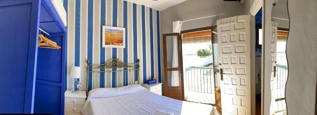 a bedroom with a blue and white striped wall at Pensión Cristina in El Rocío