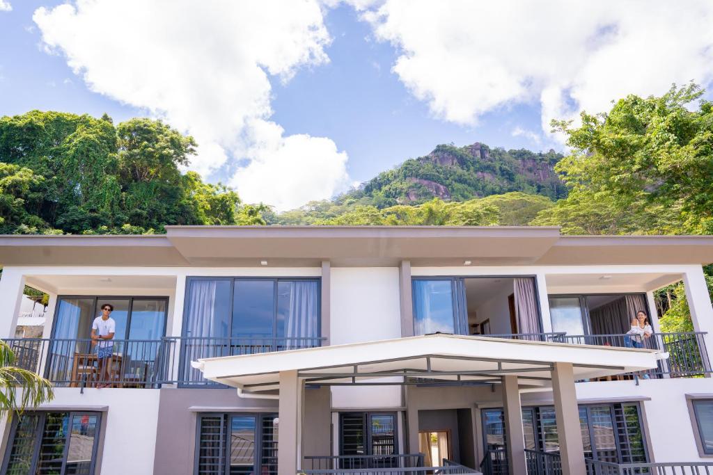 a house with a balcony with a mountain in the background at Kolibri Holiday Apartments in Victoria