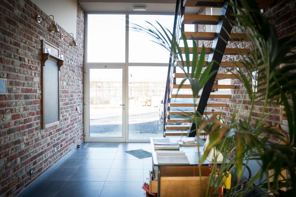 a room with a staircase and a brick wall at B&B Buytenshuys in Hooglede