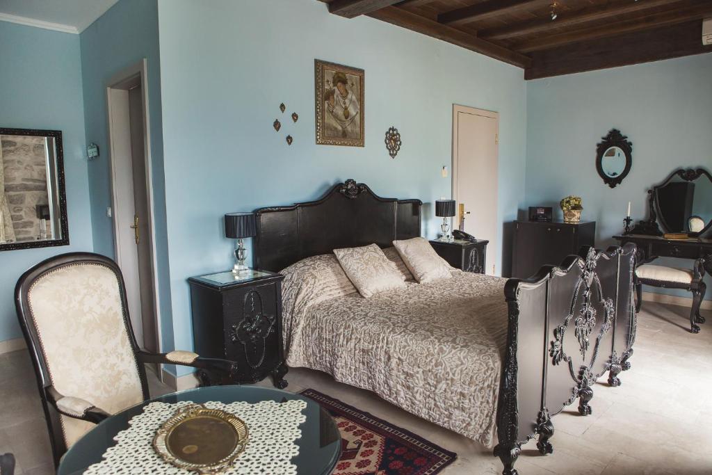 um quarto com uma cama, uma mesa e cadeiras em Palazzo Radomiri Heritage Boutique Hotel em Kotor