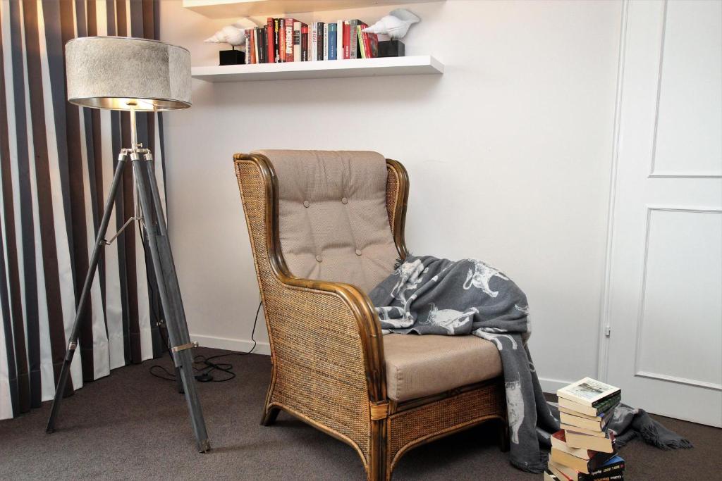 a room with a chair with a lamp and books at App. Hussmann 8/17 in Westerland (Sylt)