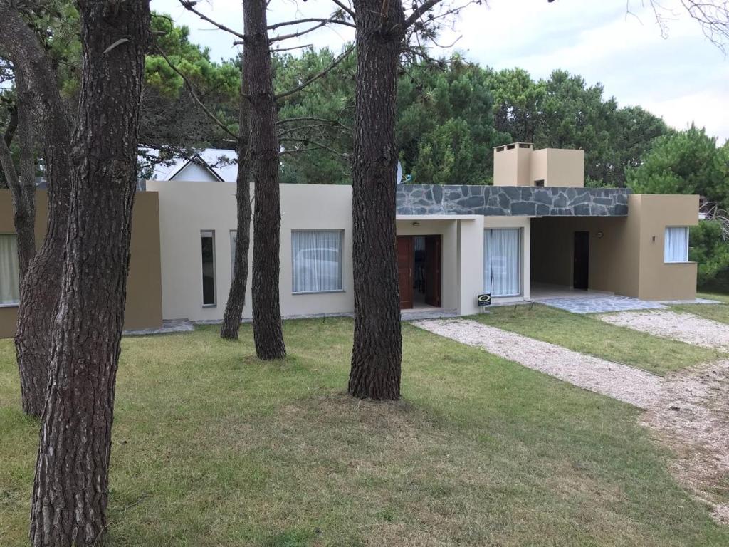 a house with trees in front of it at Casa Juno Pinamar Norte in Pinamar