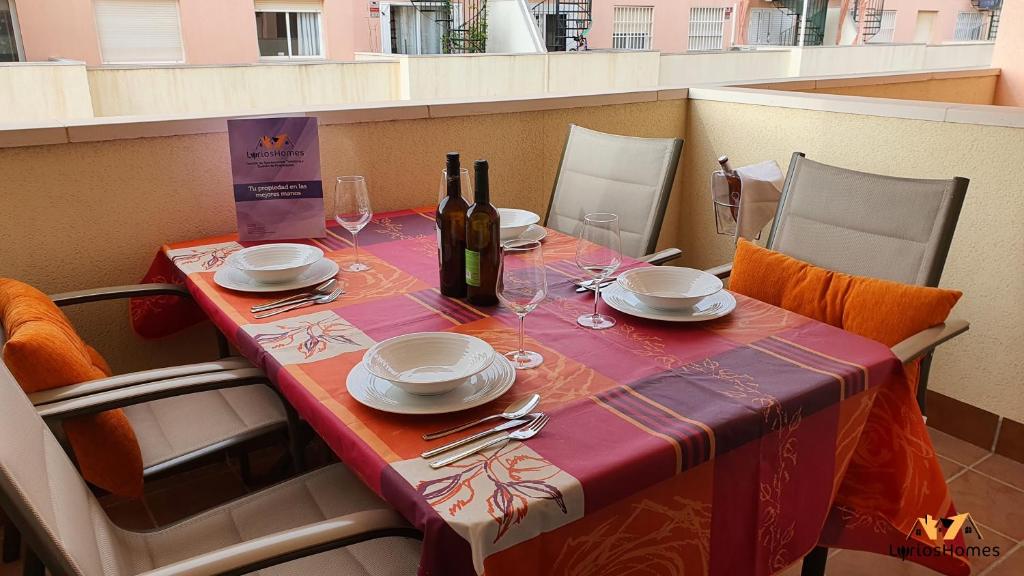 un tavolo con una bottiglia di vino e bicchieri di LyriosHomes Beach Roquetas de Mar , Piscina y parque infantil a Roquetas de Mar