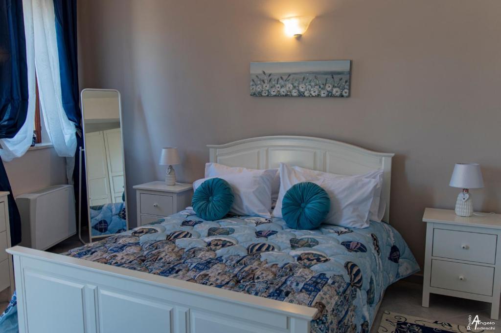 1 dormitorio con cama con almohadas azules y espejo en M&A, en Casamassima