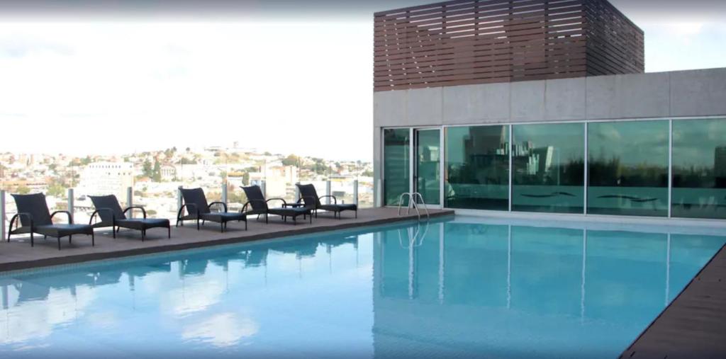 a swimming pool with chairs and a building at Rivera Casino & Resort in Rivera