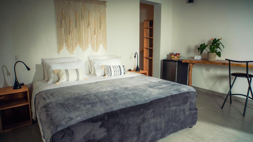 Un dormitorio con una cama grande con almohadas. en Vikara, en Olón