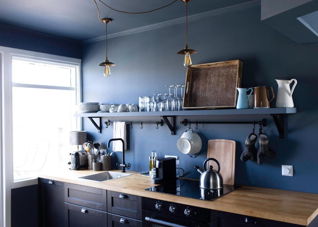 a kitchen with blue walls and a wooden counter top at INNI - Boutique apartments in Hveragerði