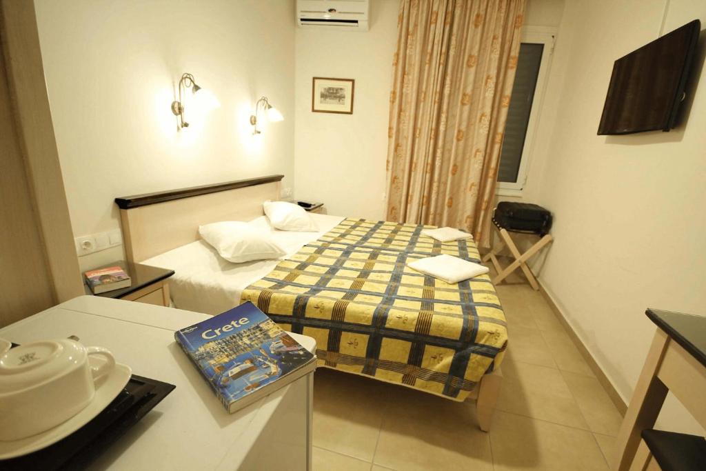 a small hotel room with a bed and a table at Mirabello Hotel in Heraklio