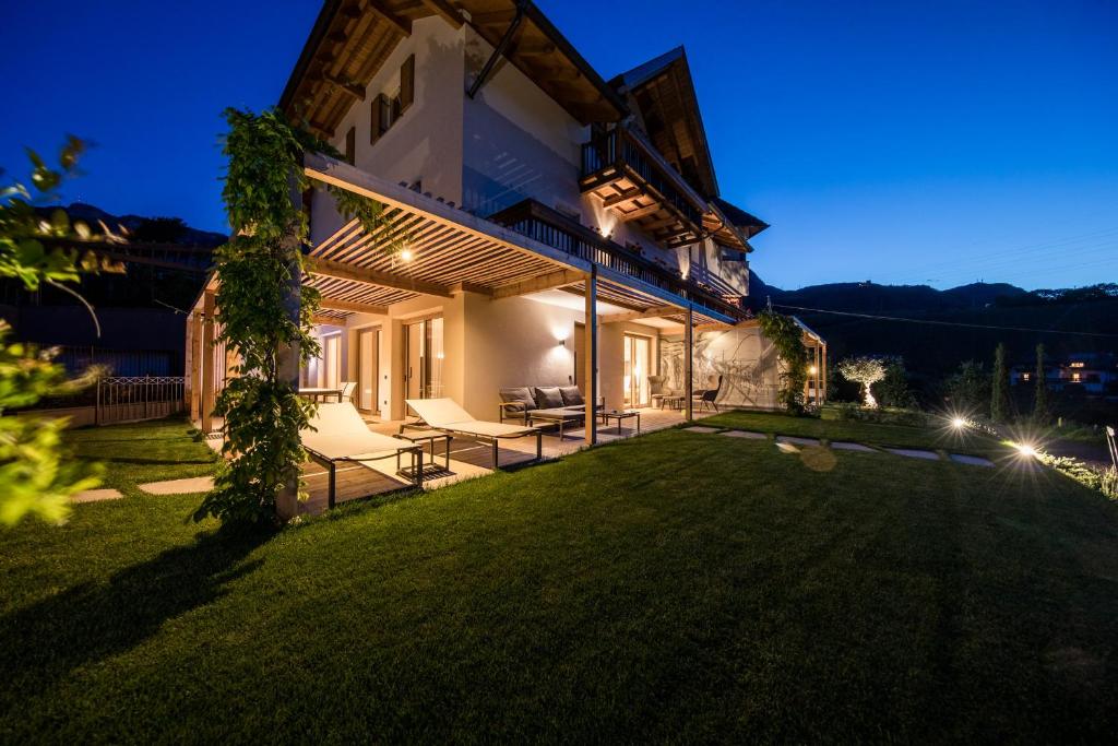 einen Hinterhof eines Hauses in der Nacht mit Lichtern in der Unterkunft SOFTALPIN Garden Suites in Appiano sulla Strada del Vino