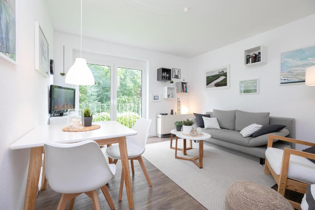 uma sala de estar com uma mesa e um sofá em Apartmentanlage Wennseestraße Kleines Glück em Scharbeutz