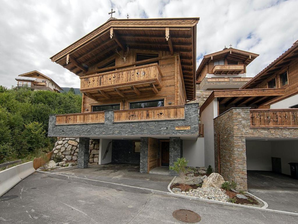 a large wooden house with a balcony on top of it at Luxury chalet with 4 bathrooms, near a small slope in Neukirchen am Großvenediger