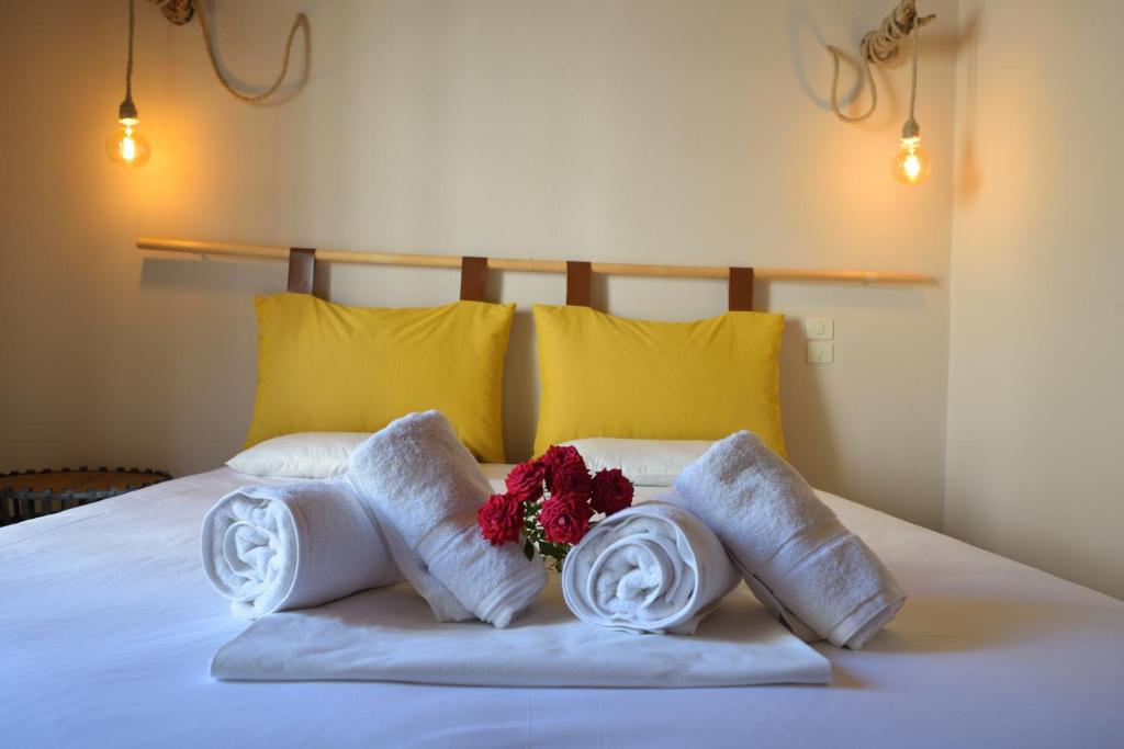 a bed with towels and a bouquet of flowers on it at Corali rooms pelion in Agios Ioannis Pelio
