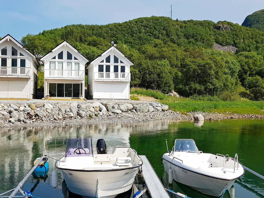 Brattvåg的住宿－Holiday home Brattvåg，两艘船停靠在房子前面的水面上