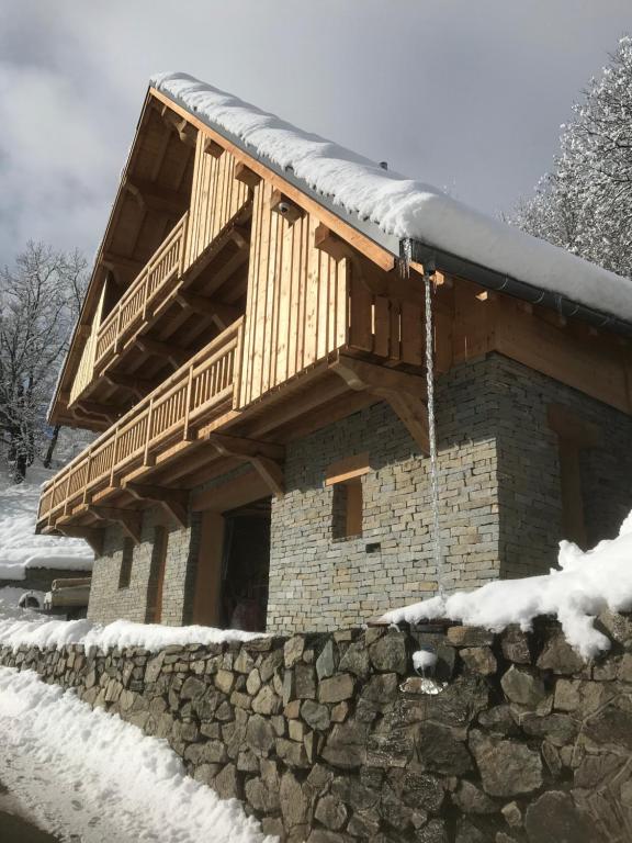 uma cabana de madeira com um telhado coberto de neve em La grange à Gaspard em Allemont