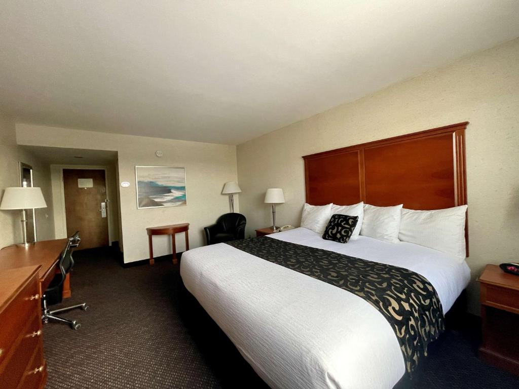 a hotel room with a large bed and a desk at Best Western Plus Waterville Grand Hotel in Waterville