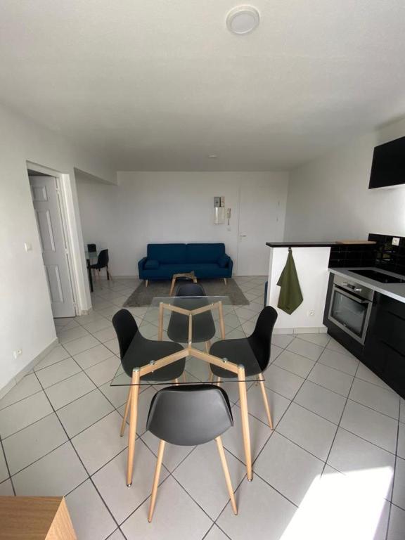 a living room with a table and chairs and a couch at F2 Lamentin in Le Lamentin