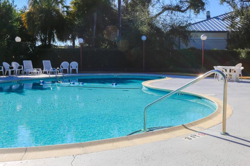 a swimming pool with blue water and chairs in it at Beachside Cottage in Isle of Palms