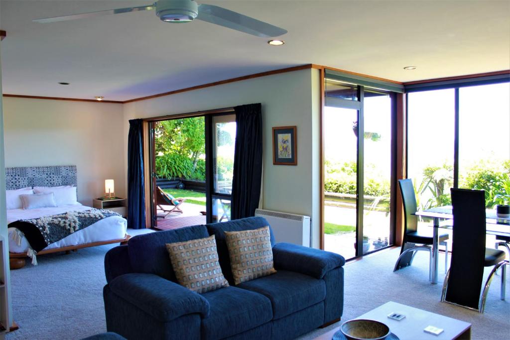 a living room with a couch and a bed at Lake View Garden Apartment in Taupo