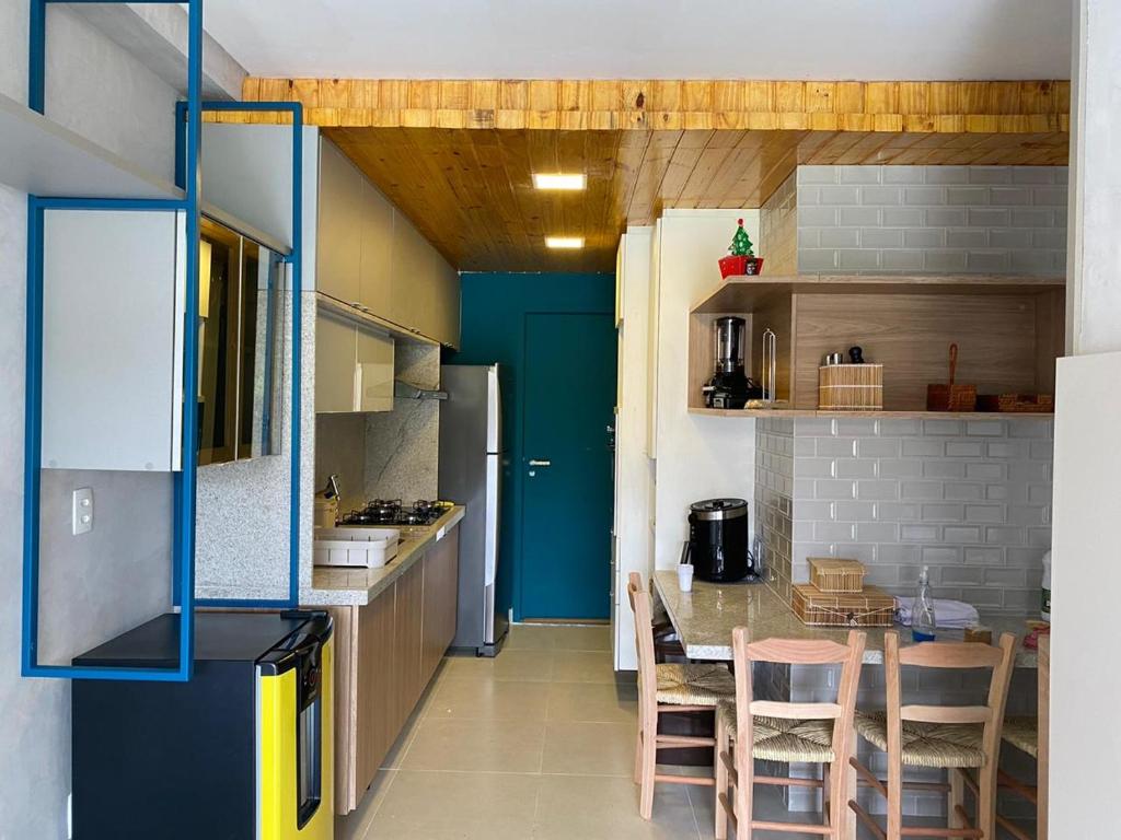 a kitchen with a table and some chairs in it at Flat 113 Eco Resort Praia dos Carneiros in Praia dos Carneiros