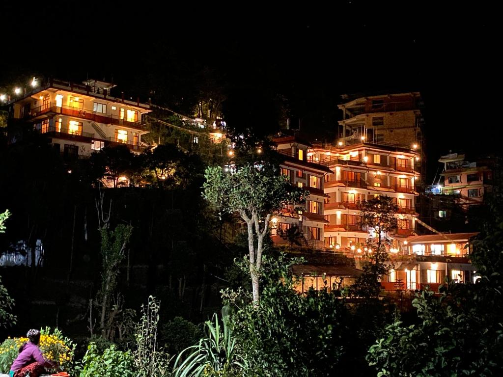 een gebouw op een heuvel met 's nachts licht bij Gaia Holiday Home in Dhulikhel