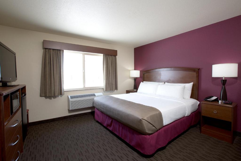 a hotel room with a large bed and a window at AmericInn by Wyndham Medora in Medora