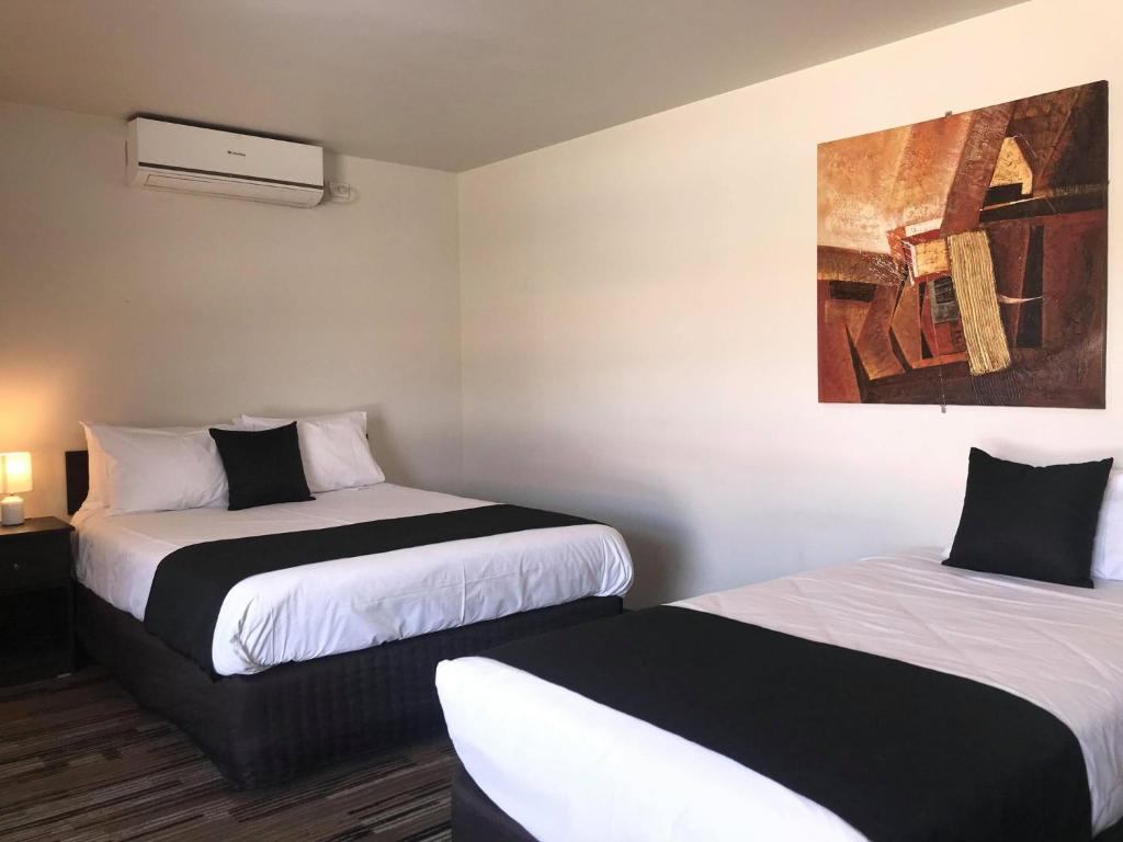 Pokój z dwoma łóżkami i obrazem na ścianie w obiekcie Guiding Star Motel & Hotel w mieście Brooklyn