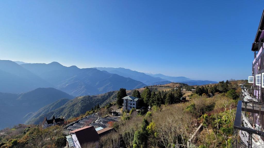 a town on a hill with mountains in the background at Maple Leave Holiday Villa in Renai