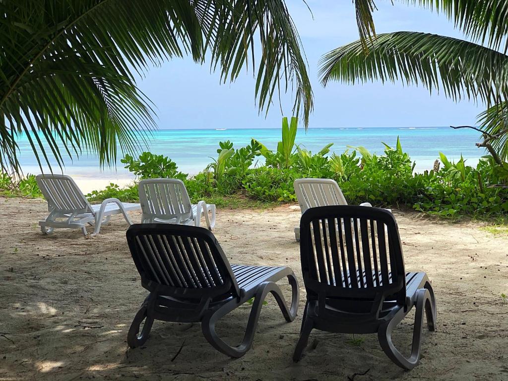 three chairs and a table on a beach at La Voi del Mare in Grand Anse