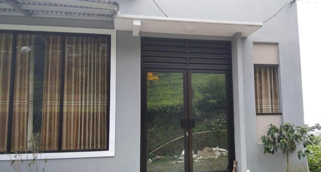 een voordeur van een huis met een raam bij RR Homestay Seroja in Garung