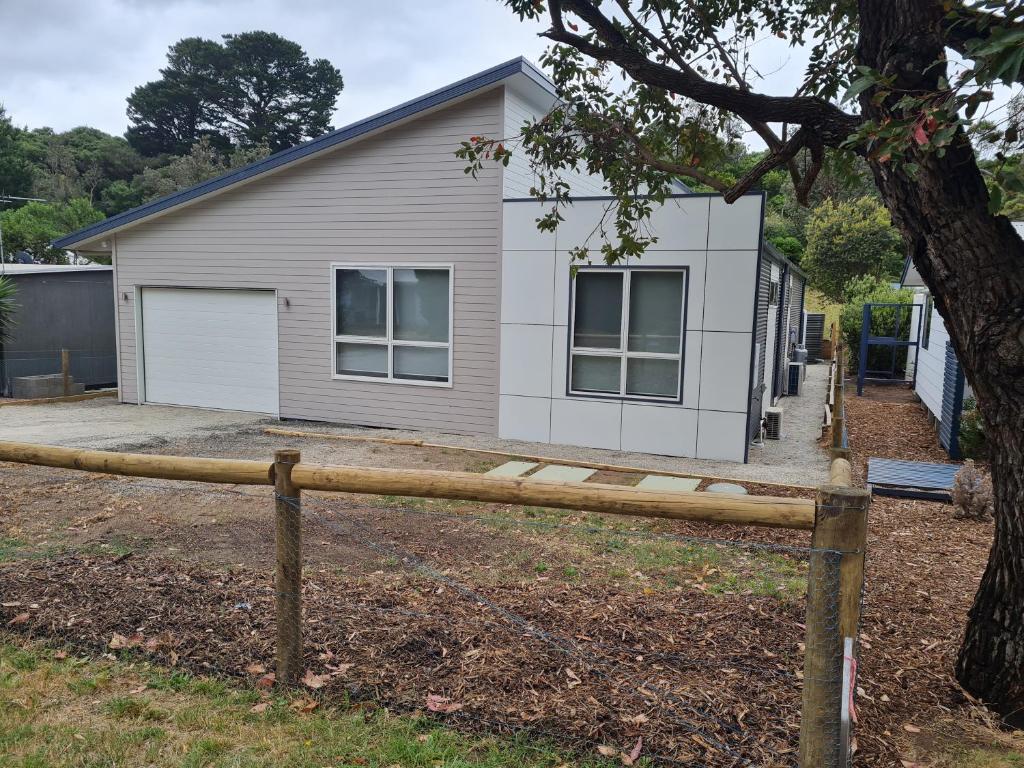 une maison avec une clôture devant elle dans l'établissement Pandora's Escape, à Venus Bay