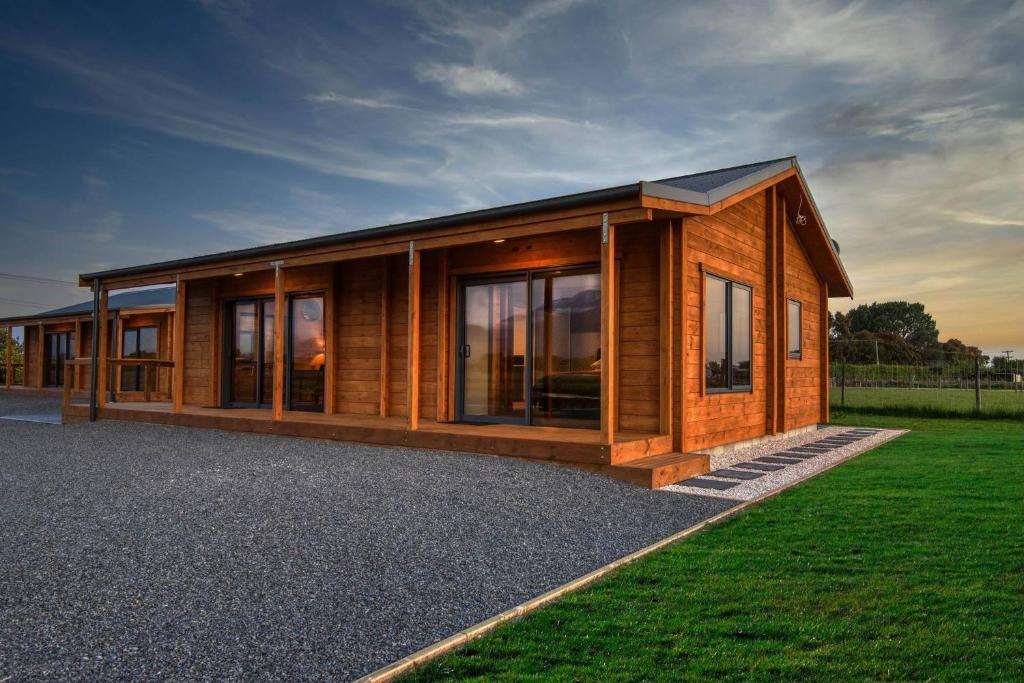 a wooden house with a lot of windows at Deerbrooke Kaikōura Chalets - Chalet 1 in Kaikoura