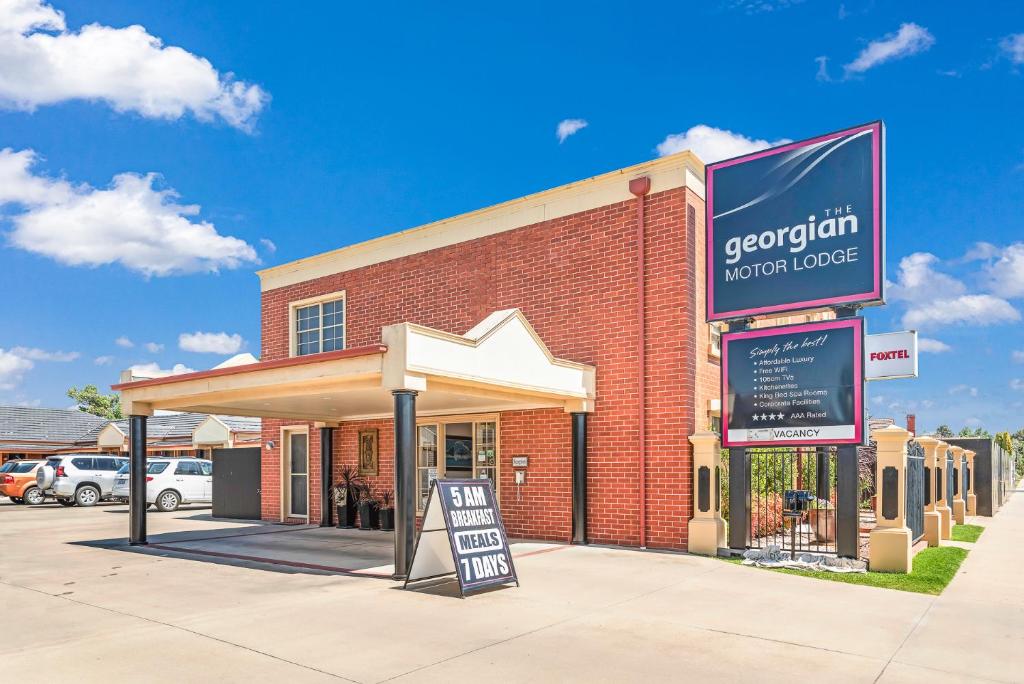 een bakstenen gebouw met een bord ervoor bij Georgian Motor Lodge in Echuca