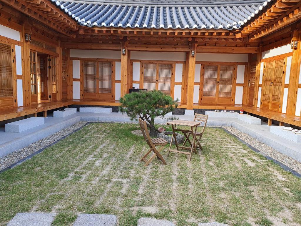 une terrasse avec une table et un arbre en face d'un bâtiment dans l'établissement SiEunJae, à Gyeongju