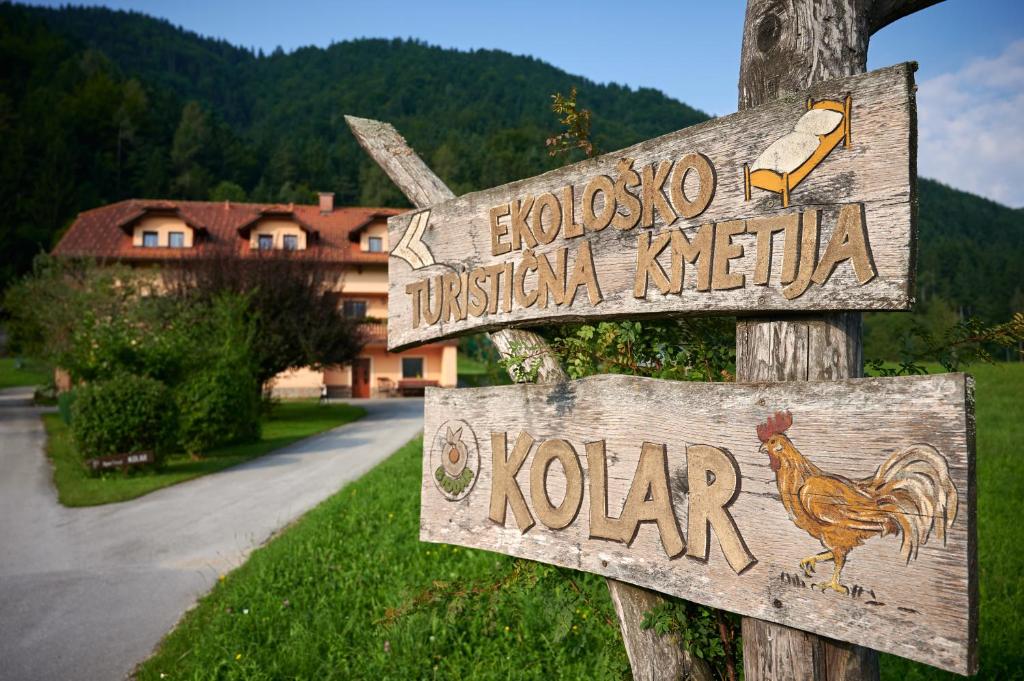 un cartel de madera para un pueblo con un pollo. en Tourist farm Kolar en Ljubno