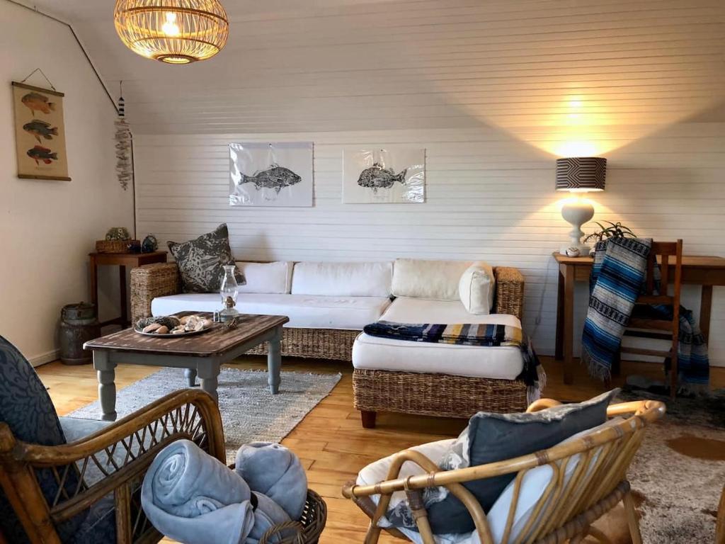 a living room with a white couch and chairs at Renovated Fishermans Cottage in Hermanus